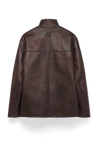 Bruine leren jas met een zachte textuur, hoge kraag en een vierkante patch op de bovenrug. Beschikt over subtiele stiksels en een getailleerde vorm.