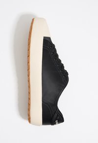 Sneaker in pelle nera con puntale in gomma bianca e suola in gomma beige. Presenta lacci neri piatti e dettagli di cucitura sui lati.