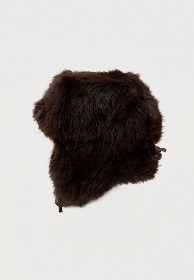 Chapéu de pele sintética castanha com topo arredondado e abas para as orelhas prolongadas, apresentando laços ajustáveis de cada lado para um ajuste seguro. Superfície macia e texturada.