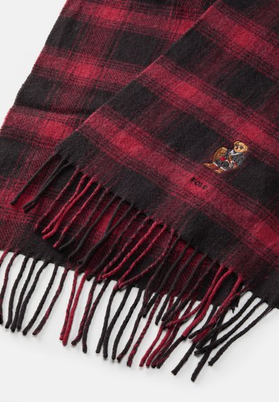 Cachecol em padrão xadrez vermelho e preto, feito em tecido suave, com bordas franjoradas. Apresenta um design de urso bordado perto da parte inferior, adicionando um detalhe distinto.