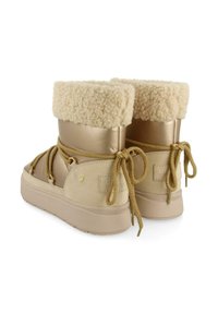 Botas de tobillo beige con un collar de crema esponjoso, detalles metálicos dorados, cordones de cuerda y un acabado de ante texturizado en el costado.