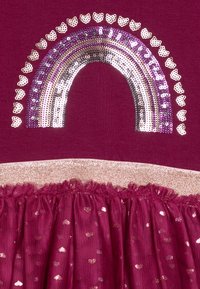 Abito bordeaux con un design arcobaleno di paillettes in viola e argento. La gonna presenta una vita con dettagli dorati e un sovrapposto a volant scintillante.
