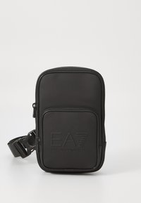 Sac à épaule multifonction noir en matériau synthétique lisse. Dispose d'une poche zippée à l'avant et du logo EA7 en relief. Sangle réglable incluse.