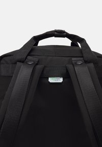 Schwarzer Rucksack mit verstellbaren Trägern und einem oberen Griff. Merkmale ein Vegatex-Etikett, glatte Textur und strapazierfähiger Stoff.