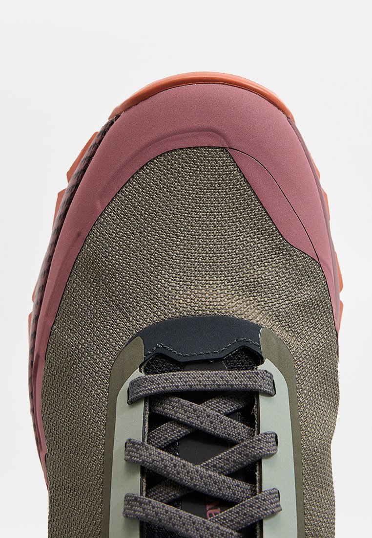 Chaussure de randonnée avec une tige en olive texturé, des accents en caoutchouc rose, un laçage noir et un embout renforcé pour plus de durabilité.