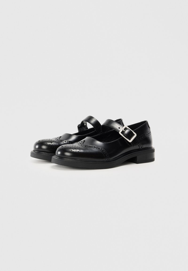 Chaussures Mary Jane en cuir noir avec un bout arrondi, des détails brogue, une bride ajustable et un petit talon carré. Surface lisse et design classique.