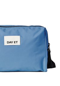 Blue nylon bag with a rectangular shape, featuring a front label with "DAY ET" in black. It has a secure zipper closure and a side strap.