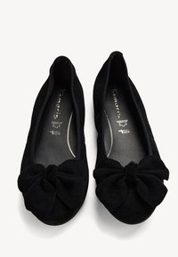 Svarta mockaskor med rund tå och en framträdande rosettdekoration framtill. Mjuk textur och vadderad innersula för komfort.