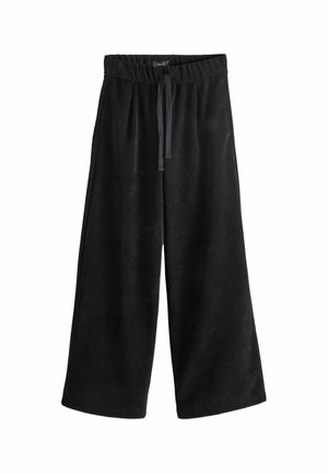 Pantalon en velours côtelé noir à jambes larges avec taille élastique et cordon de serrage devant sur fond blanc.