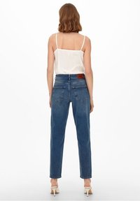 Blå denim höga jeans med rak bendesign, femfickorsstil, bakstycke och läderlogg ovanför höger ficka.