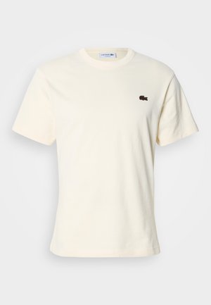 Cream cotton T-shirt with a crew neckline and short sleeves. Features a small brown embroidered crocodile logo on the left chest.