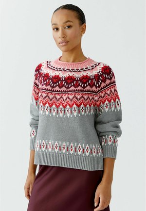 Grijze gebreide trui met een rood en roze Fair Isle patroon, met een ronde halslijn en geribde manchetten, weergegeven over een bordeauxrood rokje.