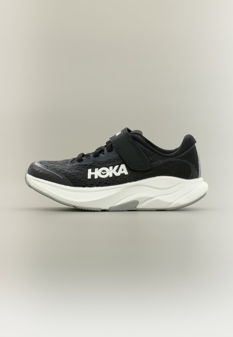 Μαύρο αθλητικό παπούτσι Hoka με λευκή σόλα, άνω μέρος από διαπνέον πλέγμα, κορδόνια και λουράκι βέλκρο στο πάνω μέρος για ασφαλή εφαρμογή.