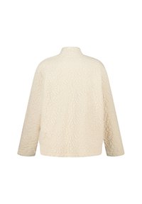 Gequilted crèmekleurige jacket met een hoge kraag, lange mouwen en een textuur met bloemenpatroon. Heeft een ontspannen pasvorm en een zachte, gladde stof.