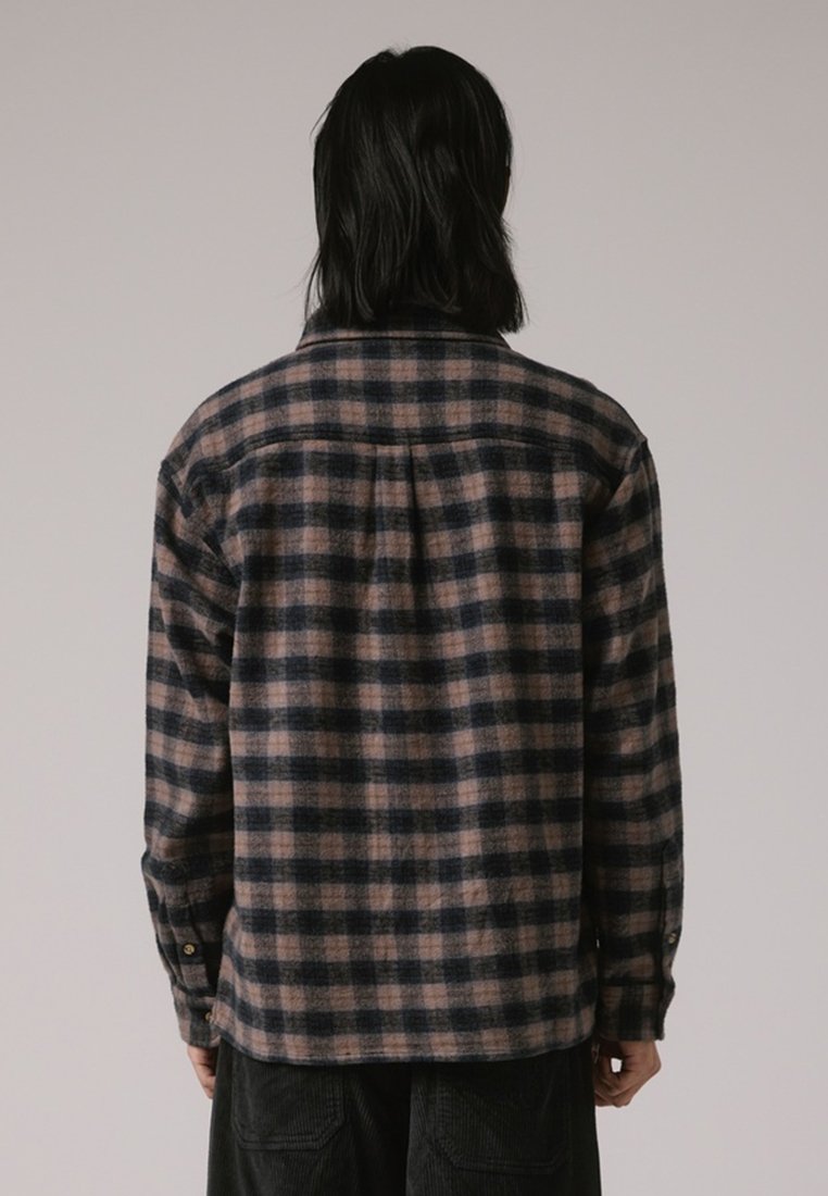 Camicia di flanella con un motivo a quadri navy scuro e chiaro, caratterizzata da un colletto, polsini con bottone e una vestibilità comoda. Tessuto testurizzato con un aspetto caldo.