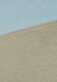 Zwei strukturierte Stoffpaneele: eines hellblau, das andere beige. Beide verfügen über eine weiche, gewebte Oberfläche mit subtilen Mustern, die durch Schlaufen erzeugt werden.