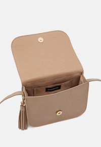 Beige kabelka přes rameno vyrobená z hladkého materiálu, s překlopným víkem se zlatým cvokem a ozdobnou třásní na boku.