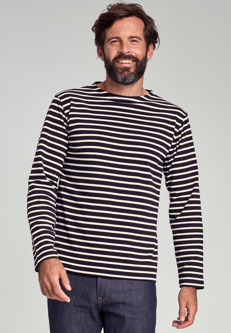 Marineblå og cremet stribet langærmet skjorte lavet af blødt stof, med rund hals og afslappet pasform, parret med mørke jeans.