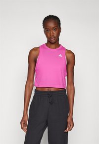 Rosa kurz geschnittenes Tanktop mit rundem Ausschnitt und ärmellosem Design. Verfügt über ein weißes Logo auf der linken Brustseite und besteht aus einem weichen Stoff.