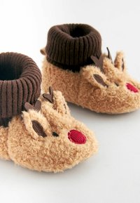 Chaussons pour bébé doux et duveteux de couleur marron en forme de rennes avec des nez rouges, des bois marron foncé et des poignets côtelés repliables.