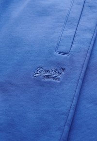 Blauwe katoenen sweatshirt met een geborduurd 'Superdry' logo. Soepele textuur met een ronde halslijn en geribbelde accenten op de mouwen.