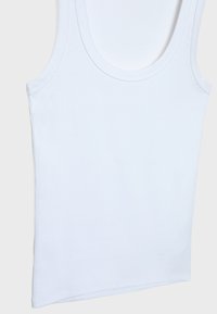 Top in cotone bianco a coste, con scollatura rotonda e spalline larghe, caratterizzato da un orlo dritto e un materiale morbido.