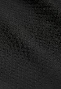 Teksturirana črna tkanina z subtilnim vzorcem, ki se ponaša z mehkim, mat videzom in finimi horizontalnimi ter vertikalnimi črtami po površini.