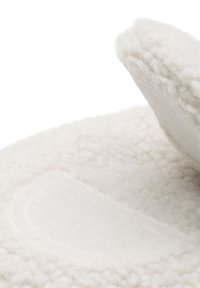 Pantoufle blanche avec une texture duveteuse, dotée d'un patch lisse et d'une forme solide. Conçue en matériau doux et chaud.