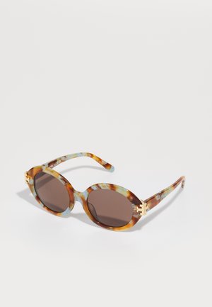 Óculos de sol em padrão tartaruga castanha com detalhes azuis, lentes ovais e acabamentos em dourado nas hastes. Proteção UV, armação leve de plástico.