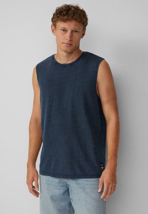 Marineblaues ärmelloses Jersey-T-Shirt mit Rundhalsausschnitt, strukturiertem Gewebe und einem kleinen Markenetikett am unteren Saum. Getragen mit hellblauen Denim-Shorts.