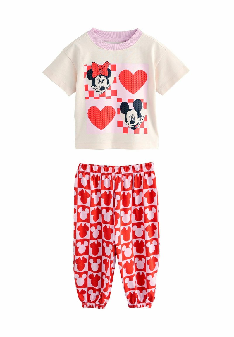 Pohodlná pyžamová souprava s Mickey a Minnie Mouse, která obsahuje krémové tričko s barevnými grafickými srdci, doplněné červenými kalhotami s bílými siluetami myšek.