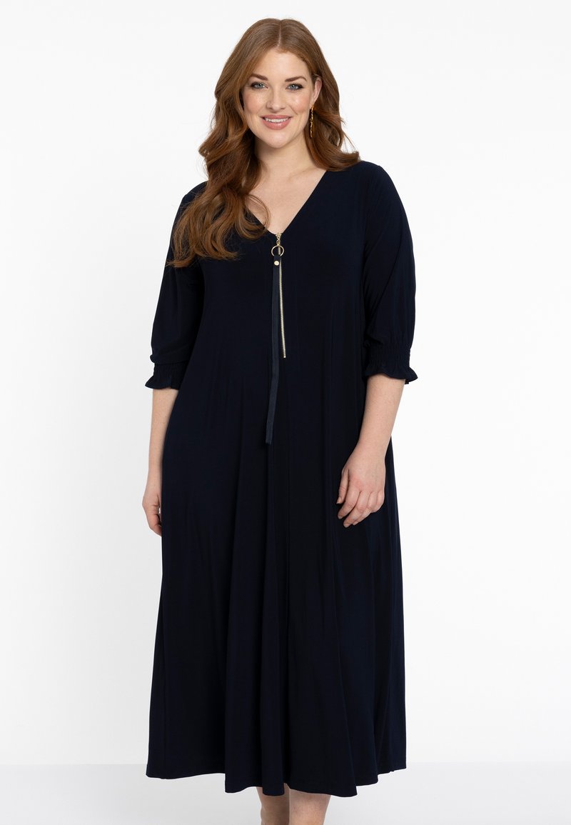 Navyblaues Midikleid mit V-Ausschnitt, goldenen Reißverschlussdetails und lockeren Ärmeln. Hergestellt aus weichem Stoff mit fließender Silhouette.