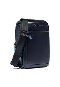 Bolso mensajero de cuero azul marino con textura suave, detalles en azul, correa ajustable y un bolsillo frontal con cremallera. Cuenta con un logotipo en la parte delantera.