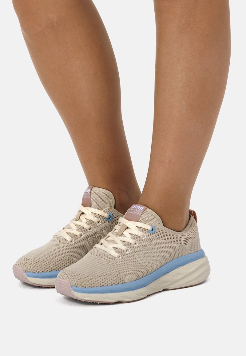 Zapatillas de malla beige con suela intermedia azul claro, cordones color crema y un sutil detalle de logo. Diseño acolchado para mayor comodidad; superficie texturizada.