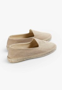 Beige espadriller med en tekstureret stofoverdel, slip-on design og flettede jutesåler. Klassisk flad form med minimale accenter.