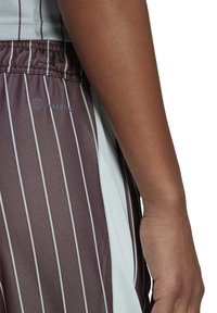 Shorts de sport marron et bleu clair avec des rayures verticales, dotés d'une taille élastique et du logo "AEROREADY" sur le côté.