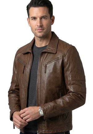 Man wearing brown leather jacket over dark grey shirt, fastening the zipper, white background.