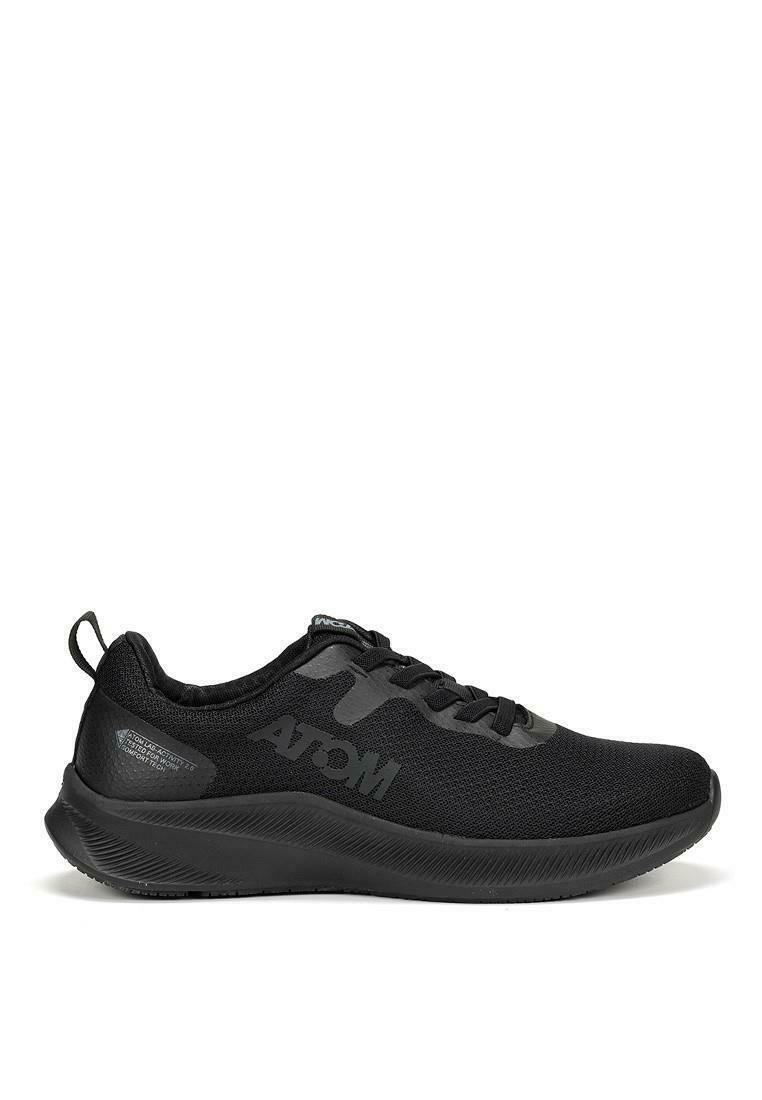 Zapato deportivo negro con parte superior de malla transpirable, suela texturizada y una marca sutil. El diseño incluye una punta redondeada y cierre con cordones.