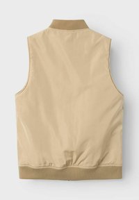 Gilet beige senza maniche con un esterno liscio e lucido. Presenta un colletto a costine e un orlo elastico, creando una forma aderente.
