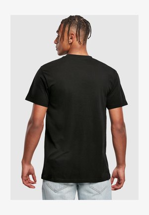 Črna bombažna majica s kratkimi rokavi in klasičnim okroglim izrezom. Gladka tekstura, sproščen kroj in preprost dizajn brez logotipov ali vzorcev.