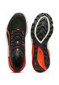 Scarpe sportive nere con accenti rossi, dotate di una tomaia in maglia texturizzata, colletto imbottito e una suola in gomma resistente con motivi di battistrada distintivi.