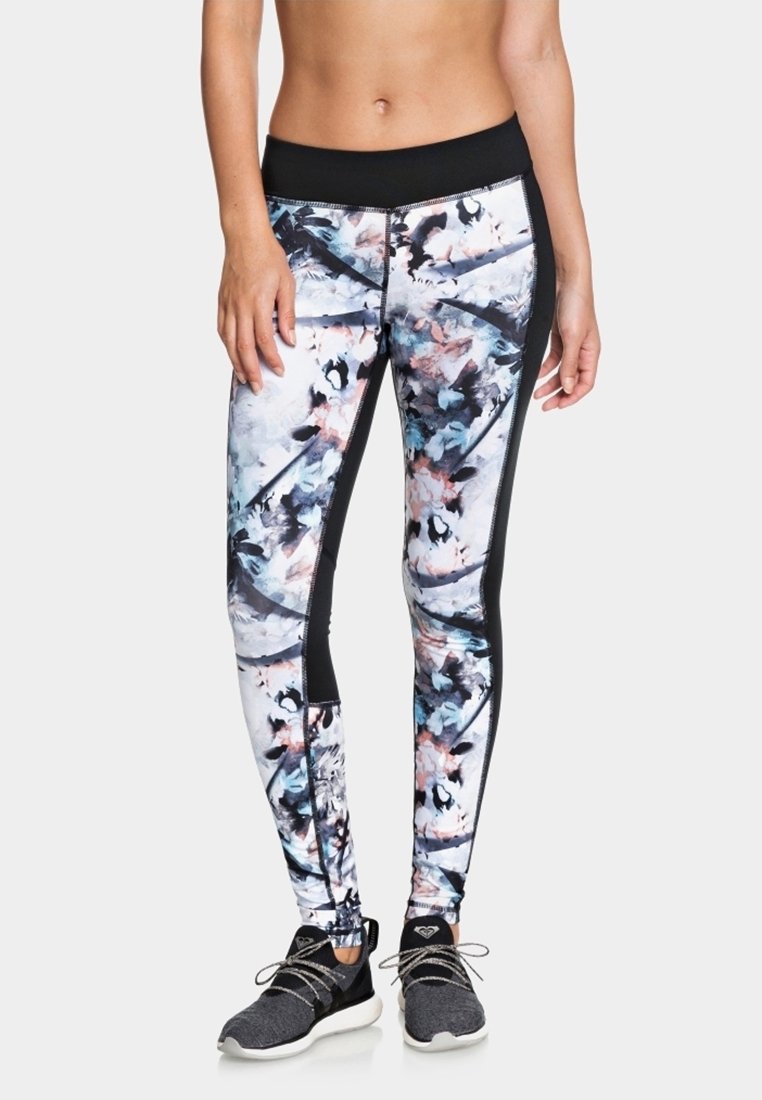 Legíny vyrobené z elastického materiálu mají barevný abstraktní vzor s černými akcenty podél stran a vysokým pasem.