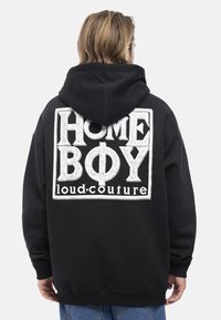 Felpa nera con un grande grafico bianco sul retro con il testo "HOME BOY loud.couture". Con cappuccio e polsini a coste.