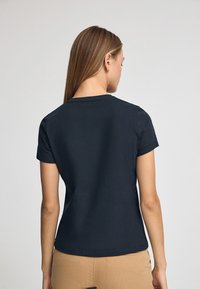Granatowa koszulka z krótkim rękawem z bawełny, z okrągłym dekoltem, charakteryzująca się gładką fakturą i dopasowanym krojem.