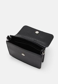 Borsa in pelle nera con texture coccodrillo, dotata di chiusura a scatto e interno aperto con più scomparti.