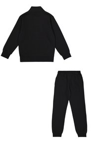 Sudadera negra con cuello y puños acanalados, combinada con pantalones jogger negros a juego que tienen una cintura elástica y perneras ajustadas.