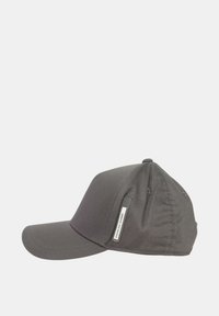 Cappello grigio realizzato in tessuto testurizzato, con visiera curva, corona morbida e un'etichetta con marchio sul lato. Design semplice e funzionale.