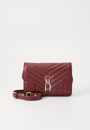 Burgundská prešívaná kožená kabelka cez rameno so zlatým reťazovým popruhom a kovovým logom na prednej klapke.