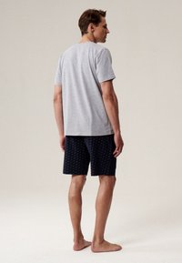 Szara bawełniana koszulka i granatowe spodenki w wzory. Koszulka jest z krótkim rękawem, a spodenki mają subtelny wzór, obie części odpowiednie do codziennego użytku.