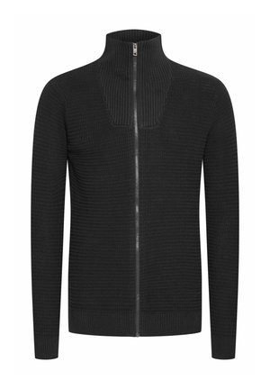 Črna pletena zip-jaketa z visokim ovratnikom, ki ima teksturiran vzorec in vitko prileganje. Kovinski zadrga poteka po sprednji strani.